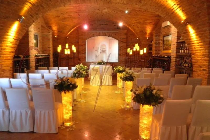 Ceremonia en una cava con velas en nichos y pasillo iluminado